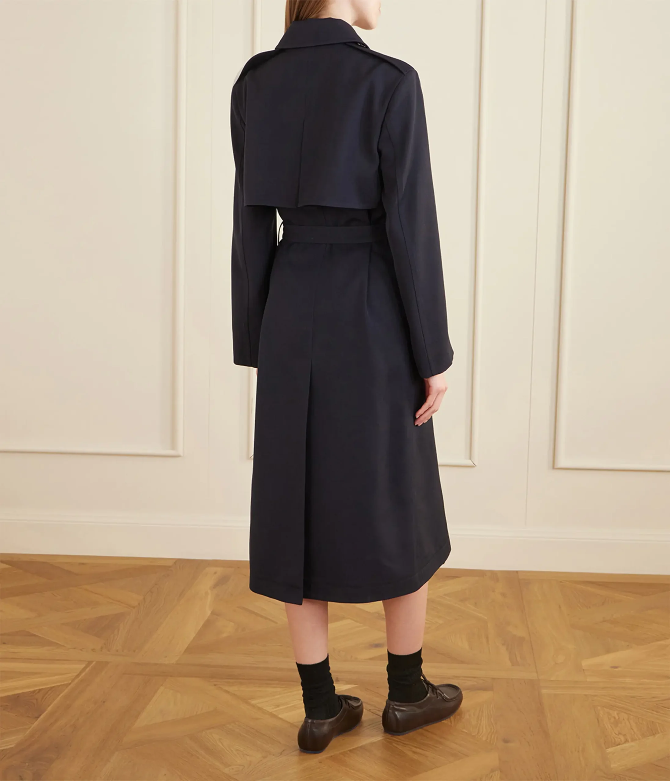 Professional apparel photo retouching service showing a model in a long navy blue coat